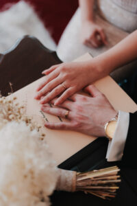 Portrait of bride and groom's hands over their signed wedding register