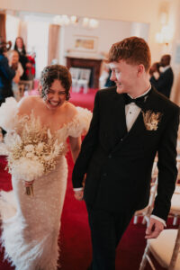 Bride and groom laughing as they leave registry office