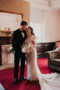 Bride and groom posed together, directed by the photographer at registry office