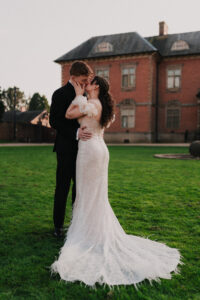 Bride and groom posed together against the manor's architecture