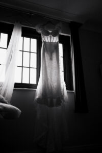 Bride's dress hanging in the window, black-and-white