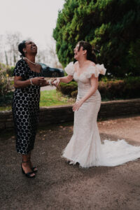 Bride and wedding guest laughing, candid moment