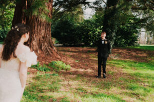 Groom walking towards bride at first look