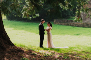Wide portrait of bride and groom talking at first look