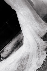 Angled close-up shot of bride's dress in black-and-white