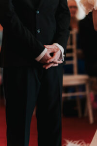 Close-up of groom's hands during ceremony at registry office