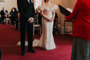 Wide shot of the officiant and the bride and grooms hands in Newport Registry Office