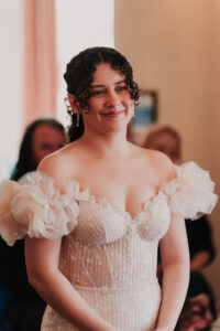 Documentary portrait of bride smiling during registry office wedding ceremony