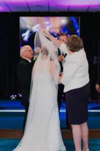 Mother and father of the bride remove bride's veil