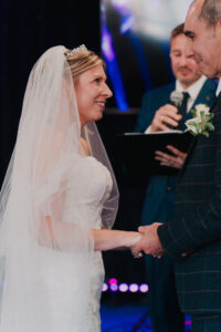 Candid portrait of bride smiling at groom for the first time