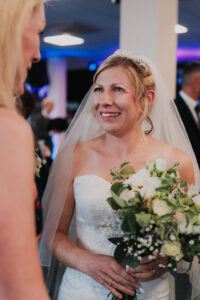 Bride smiling as she speaks with guests after the ceremony