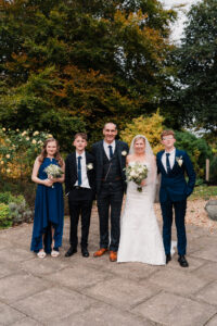 Groom and bride with their family in Wyndham Park, Grantham