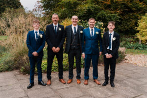 Groom and groomsmen pose for formal photo in Wyndham Park, Grantham