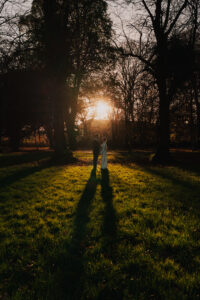 Wide portrait of bride and groom as the sun sets in Bute Park
