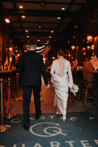 Bride and groom walking together into the arcade, candid shot