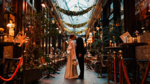 Bride and groom posed together in the arcade