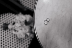 Black-and-white detail shot of the wedding bands