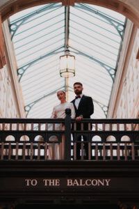 Bride and groom posing on a balcony in the Cardiff Arcades