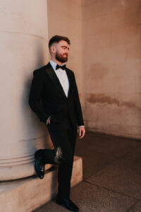 Solo portrait of the groom with one leg on the Cardiff Museum pillar