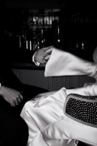 Direct flash portrait of the bride and groom holding hands at the bar in Cardiff Townhouse