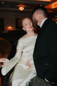 Groom kissing bride on the check, direct flash portrait