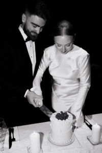 Black-and-white moment of wedding cake cut