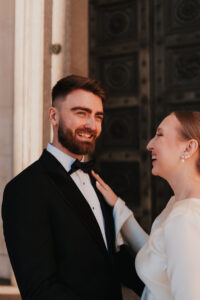 Groom smiling with bride during golden hour