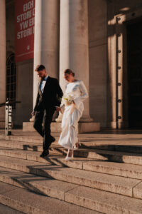 Golden hour portrait of bride and groom on the stairs of Cardiff Museum