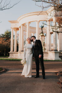 Groom kissing the cheek of his bride in Alexandra Gardens