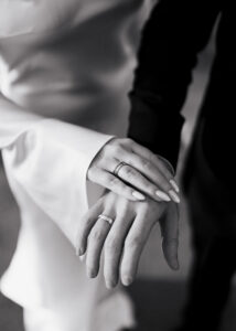 Black-and-white portrait of bride and groom showing their wedding bands