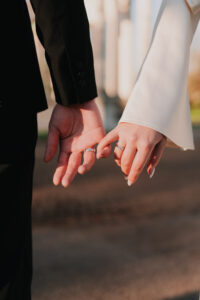Bride and groom locking pinky fingers together