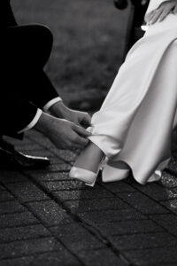 Groom fixing brides dress, candid moment