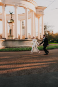 Playful blurred motion shot of the couple running through the gardens