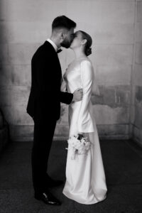 Black-and-white portrait of the bride and groom kissing at Cardiff Museum
