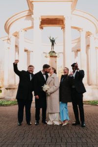 Small wedding party cheering the newly, married couple