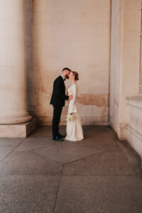 Bride and groom kissing against the museum backdrop