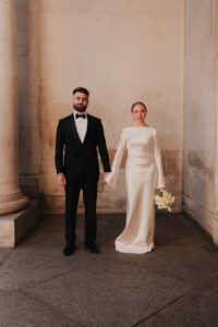 Formal portrait the bride and groom standing side by side holding hands