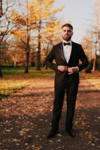 Groom fixing his suit in Bute Park