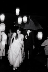 Black-and-white portrait of a bride and groom exiting their wedding at The Great Barn in Ruislip London