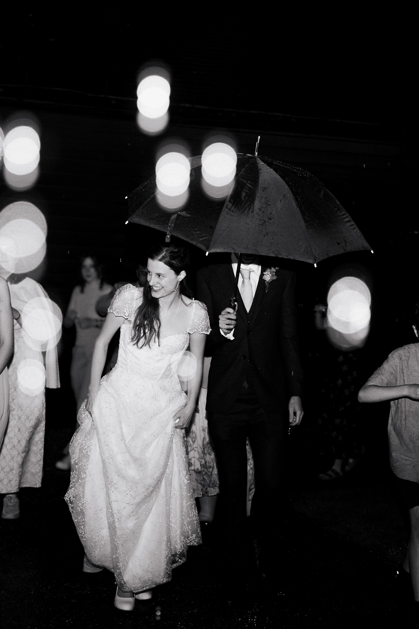 Black-and-white portrait of a bride and groom exiting their wedding at The Great Barn in Ruislip London