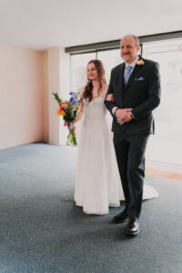 Portrait of the bride and father of the groom walking down the aisle