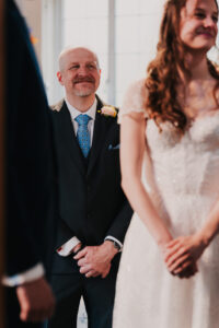 Father of the bride smiling at the bride