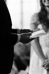 Black-and-white portrait of the groom holding his vows