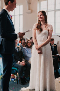 Bride smiling at the groom during wedding ceremony at Waterloo Road Church in London Ruislip