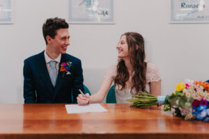 Signing of the registry at Waterloo Road Church during wedding ceremony
