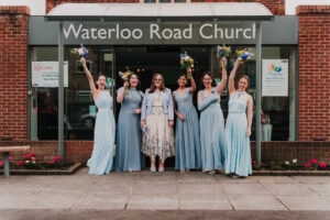 Portrait of bridesmaids cheering at Waterloo Road Church in Ruislip