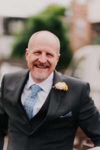 Portrait of the father of the bride smiling as he arrives at the church