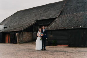 Bride and groom standing in front of The Great Barn in Ruislip London